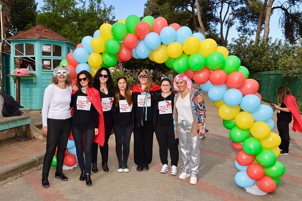 המורות מחופשות ועומדות ליד שער עם בלונים